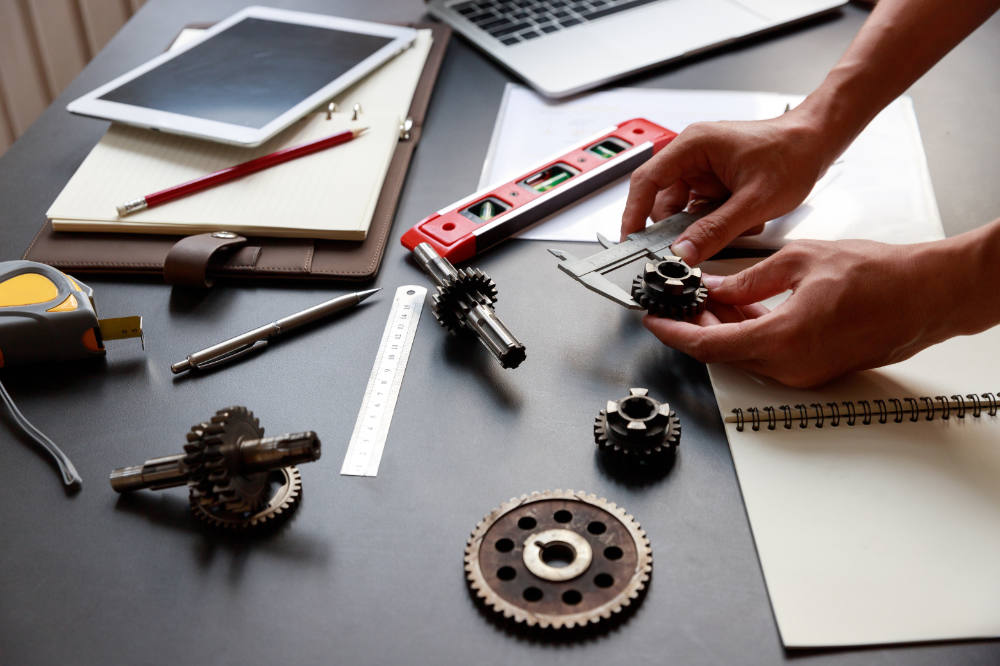 Engineer discussing and designing about mechanical gear parts in office.